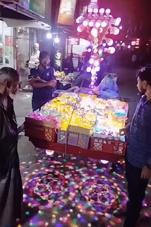 Dhaka street vendor runs a dazzling mobile light display at night