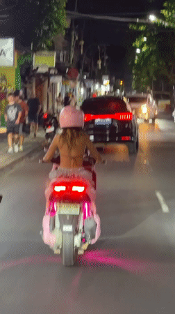 Pink scooter cruising Kuta streets after dark