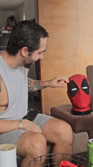 Man interacts with Deadpool mask in Surquillo living room