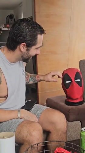 Man interacts with Deadpool mask in Surquillo living room