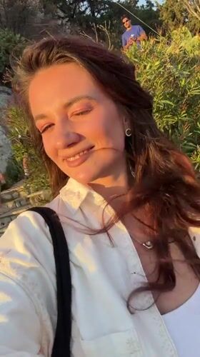 Woman records selfie video in golden light in Athens