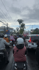Heavy traffic observed in Denpasar with motorcyclists in rain gear