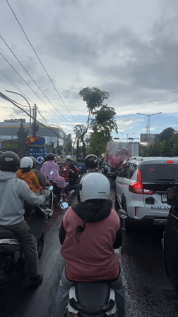 Heavy traffic observed in Denpasar with motorcyclists in rain gear