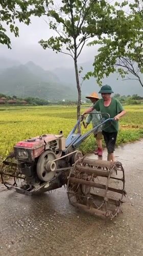 Farmers work flooded rice paddies with tillers in Vietnam
