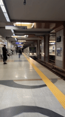 Metro train arrives at station with waiting passengers