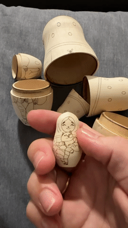 Person opens handmade cat-themed Matryoshka dolls in Florianópolis