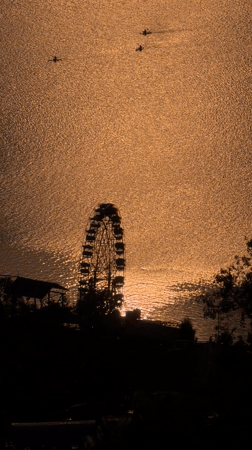 Ferris wheel sunset scene captured by boats in Pokhara