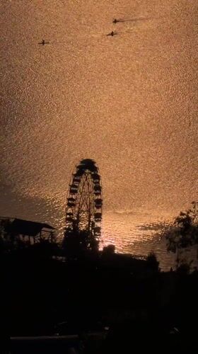 Ferris wheel sunset scene captured by boats in Pokhara