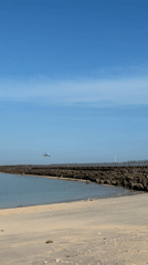 Aircraft approaches landing over water near Kuta beach Indonesia