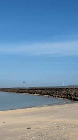 Aircraft approaches landing over water near Kuta beach Indonesia