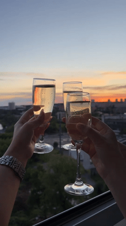 Women celebrate with champagne toast at sunset in Izhevsk
