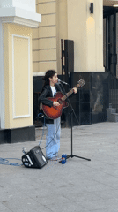 Street musician performs amid Moscow's spring blooms and luxury shops