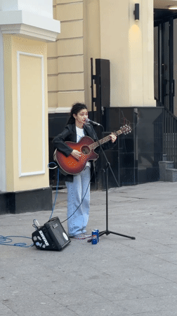 Street musician performs amid Moscow's spring blooms and luxury shops