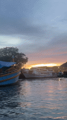 Ratsada harbor at dusk, boats moored as the sun sets