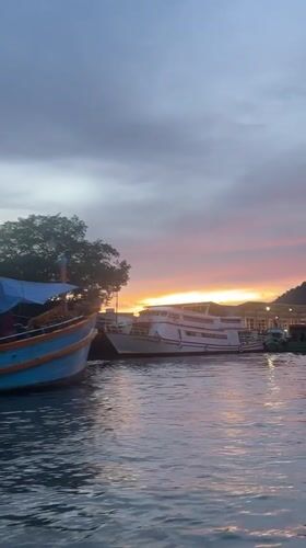Ratsada harbor at dusk, boats moored as the sun sets