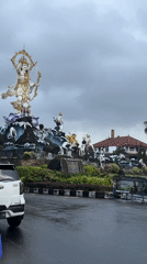 Deity statue with bow documented at Denpasar roundabout