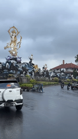 Deity statue with bow documented at Denpasar roundabout