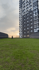 Child runs across Moscow lawn near tall building