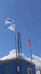 Rural Russian morning: flags, radio tower, dog, pedestrian