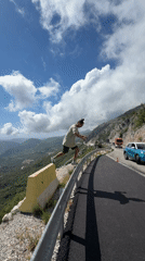 Man poses on highway guardrail in Montenegro mountains