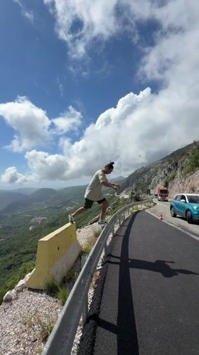 Man poses on highway guardrail in Montenegro mountains