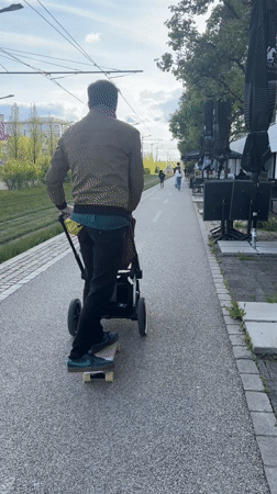 Man skateboards while pushing baby stroller in Luxembourg
