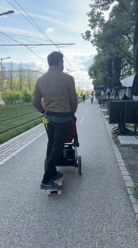 Man skateboards while pushing baby stroller in Luxembourg