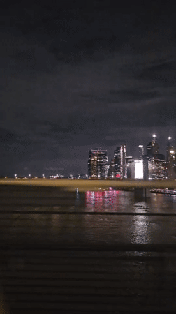 Blurry nighttime NYC skyline reflected across the water