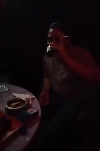 Person drinks and smokes at Dhaka bar establishment