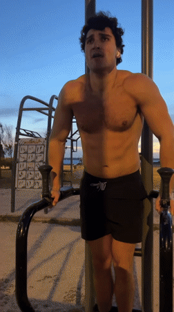 Man exercises on parallel bars in Porto park
