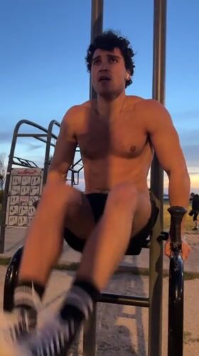 Man exercises on parallel bars in Porto park