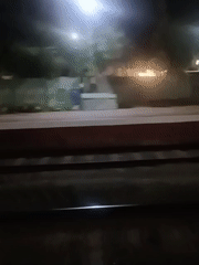 Nighttime train rolls past Mallasandra station platform