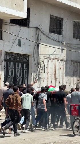Gaza residents carry flag-draped body in street procession