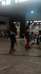 People dance in empty warehouse space with sewing equipment