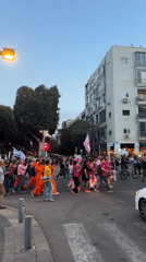 Flag-bearing crowd marches through Tel Aviv with musical accompaniment