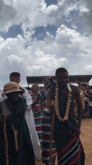 Traditional-dressed group walks before crowd in Durimi, Nigeria