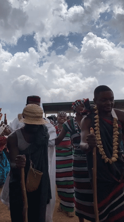 Traditional-dressed group walks before crowd in Durimi, Nigeria
