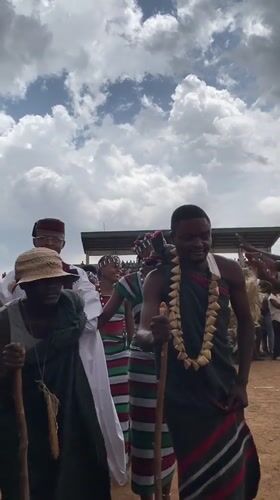 Traditional-dressed group walks before crowd in Durimi, Nigeria