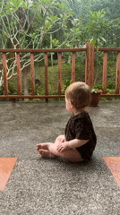 Baby plays on wet patio in rural Thailand