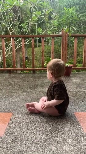Baby plays on wet patio in rural Thailand