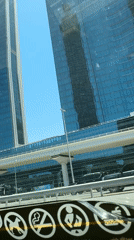 Dubai skyline photographed from vehicle on sunny morning