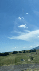 Driver travels scenic rural roads near Komuniga on sunny day