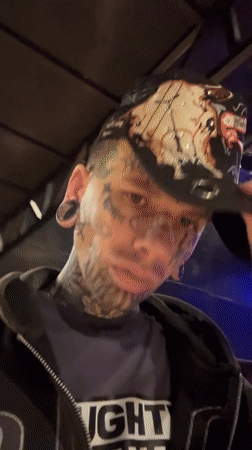 Tattooed individual films selfie near empty Buenos Aires performance hall