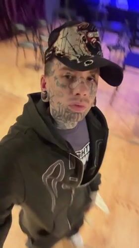 Tattooed individual films selfie near empty Buenos Aires performance hall