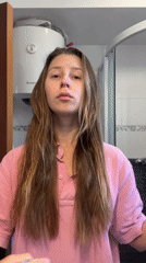 Woman applies hair products during morning routine in Montenegro