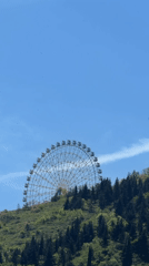 Ferris wheel spotted on hilltop in Tbilisi under clear skies