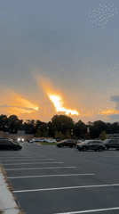 Crepuscular rays break through storm clouds over a Vienna parking lot