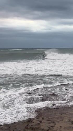 Surfers brave large waves in rough conditions at Bulli