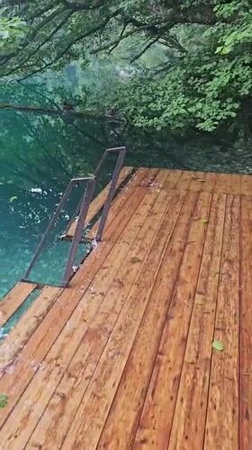Turquoise lake and wooden dock in the Caucasus mountains