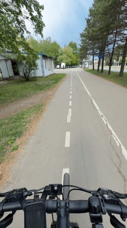Woman cycles tree-lined bike path in Birobidzhan, Russia